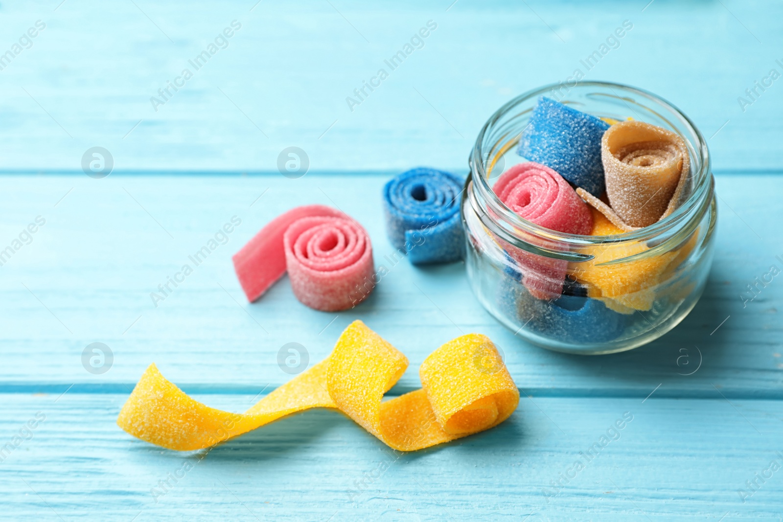 Photo of Jar of delicious chewing candies on wooden table