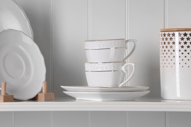 Photo of Stylish storage stand with different ceramic dishware at home