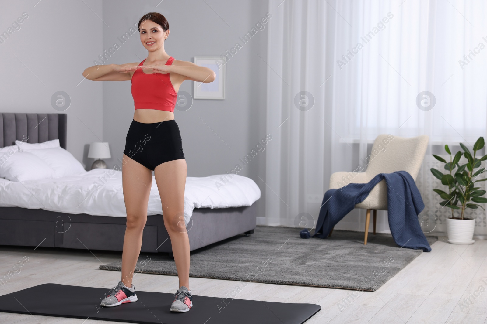 Photo of Happy woman doing morning exercise at home, space for text