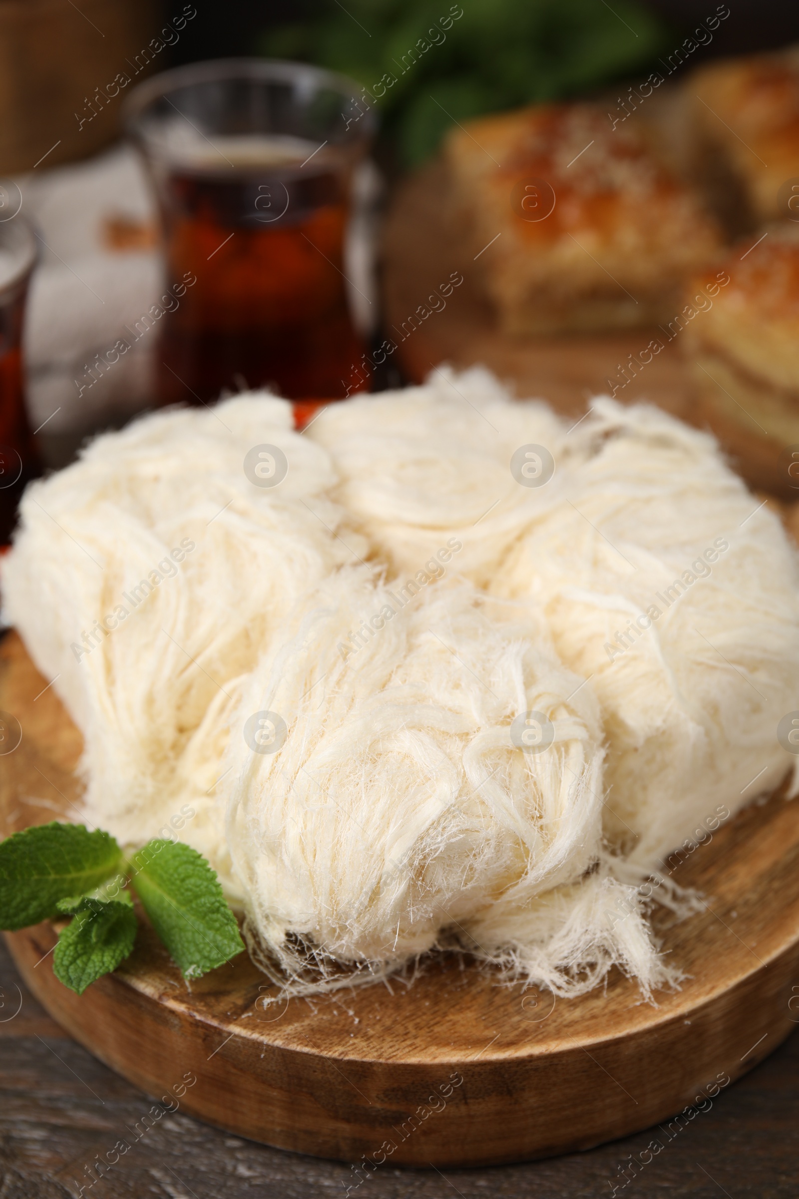 Photo of Eastern sweets. Tasty Iranian pashmak on wooden table, closeup