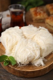 Photo of Eastern sweets. Tasty Iranian pashmak on wooden table, closeup