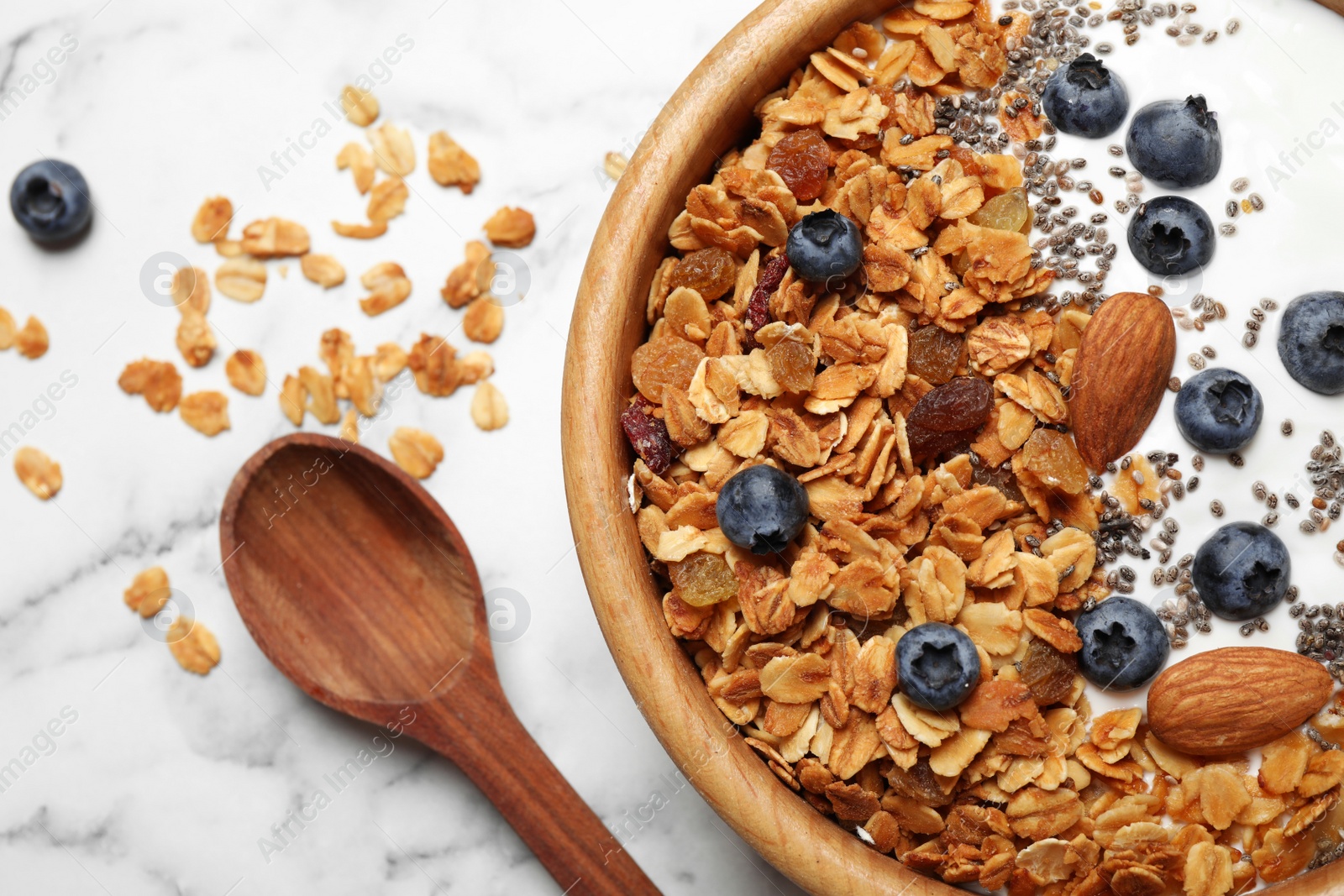 Photo of Tasty homemade granola served on white marble table, flat lay. Healthy breakfast