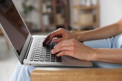 Young woman working with laptop at home, closeup