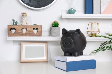 Photo of Color piggy bank on table in room. Cute interior element