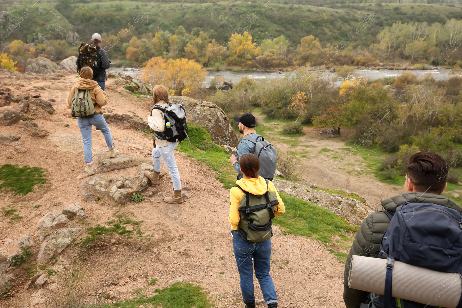 Photo of Group of hikers with backpacks climbing up mountains