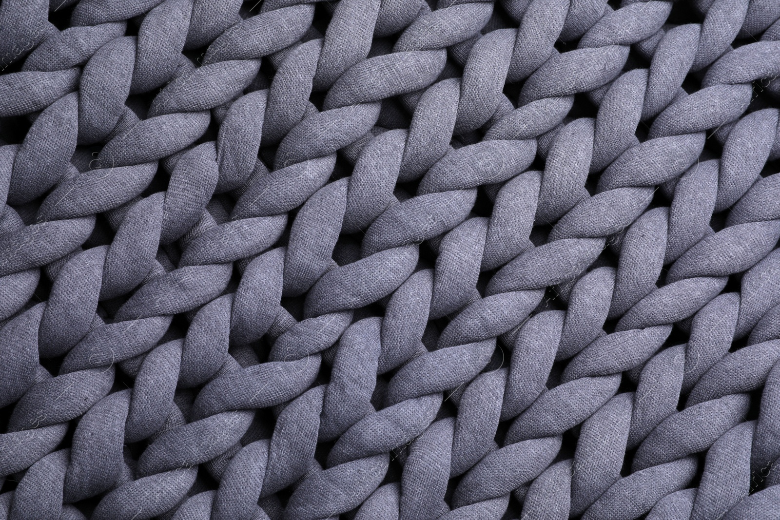 Photo of Top view of grey chunky knit blanket as background