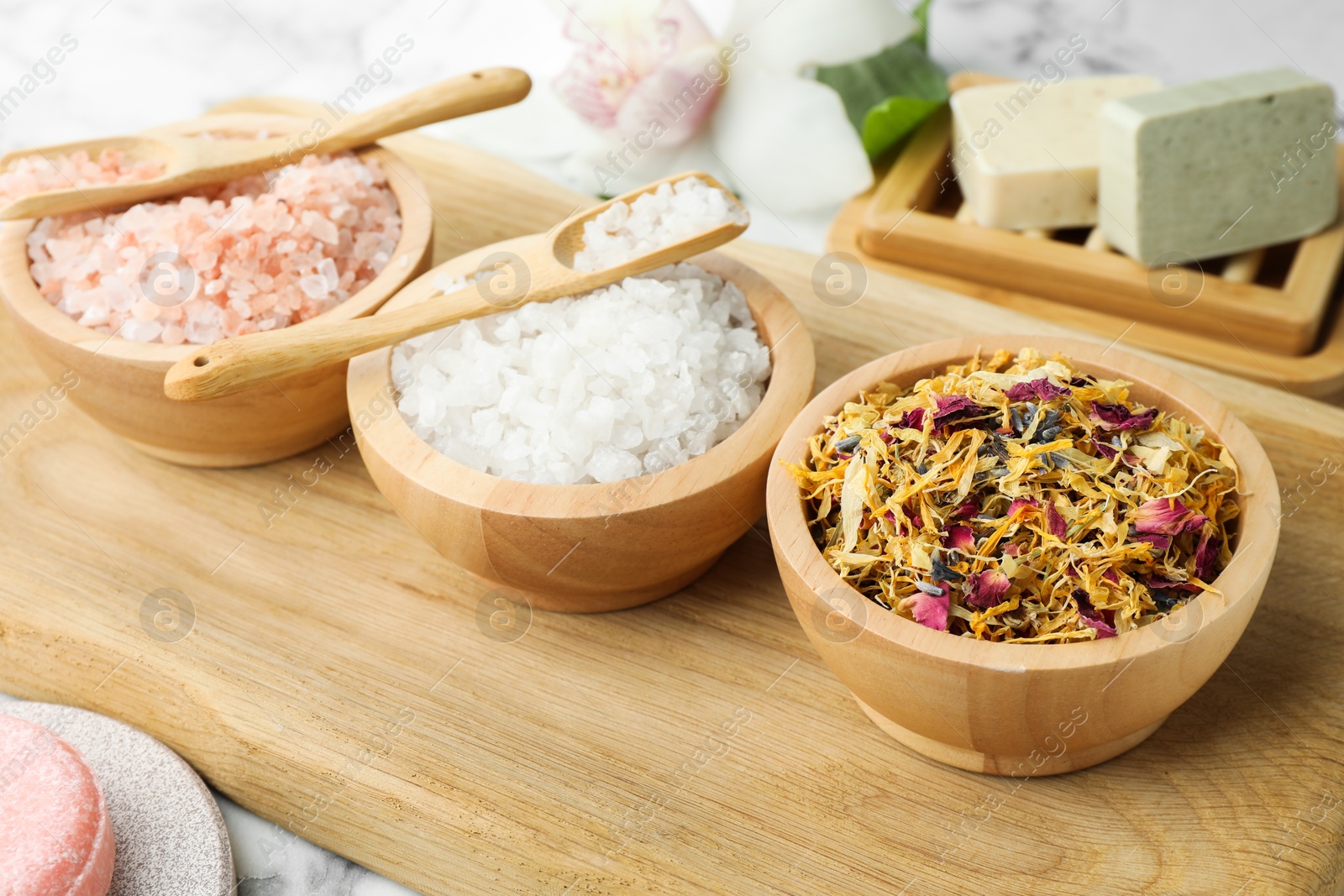 Photo of Spa composition with sea salt and dry flowers in bowls on table