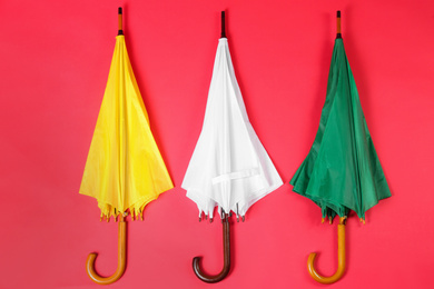 Colorful umbrellas on red background, flat lay