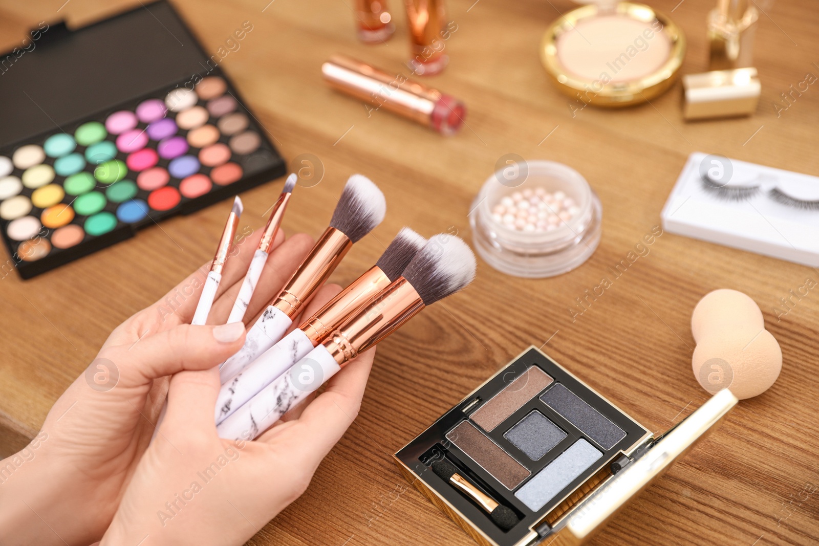 Photo of Beauty blogger with set of makeup brushes at table, closeup