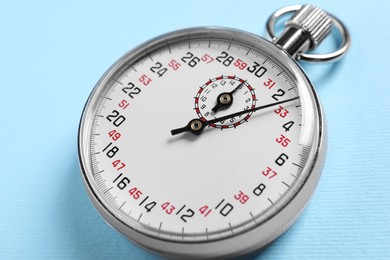 Photo of Vintage timer on light blue background, closeup. Measuring tool