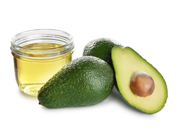 Photo of Jar of natural oil and avocados isolated on white