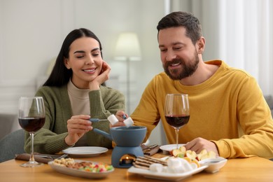 Photo of Affectionate couple enjoying fondue during romantic date at home