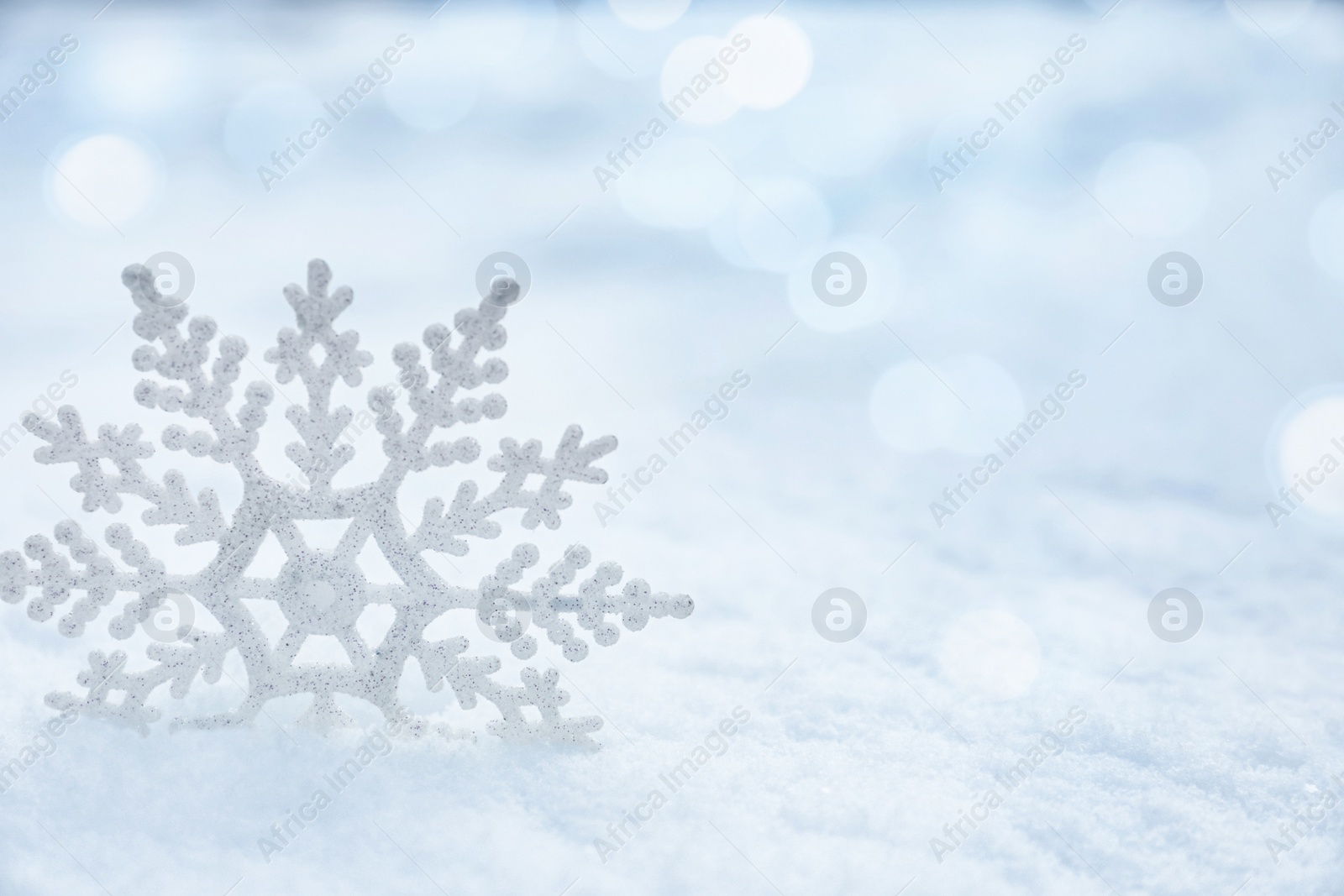 Image of Beautiful decorative snowflake on white snow. Space for text