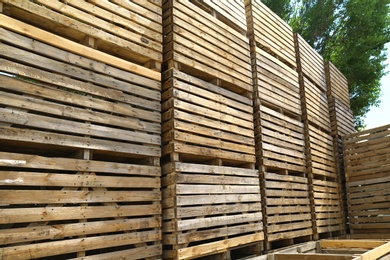 Pile of empty wooden crates outdoors on sunny day