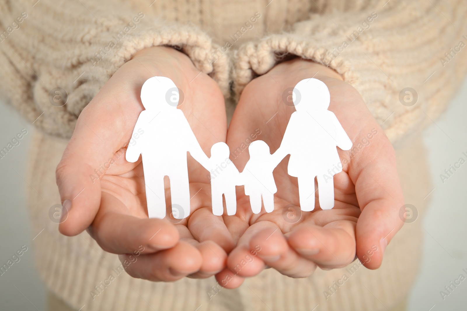 Photo of Woman holding paper family cutout, closeup view