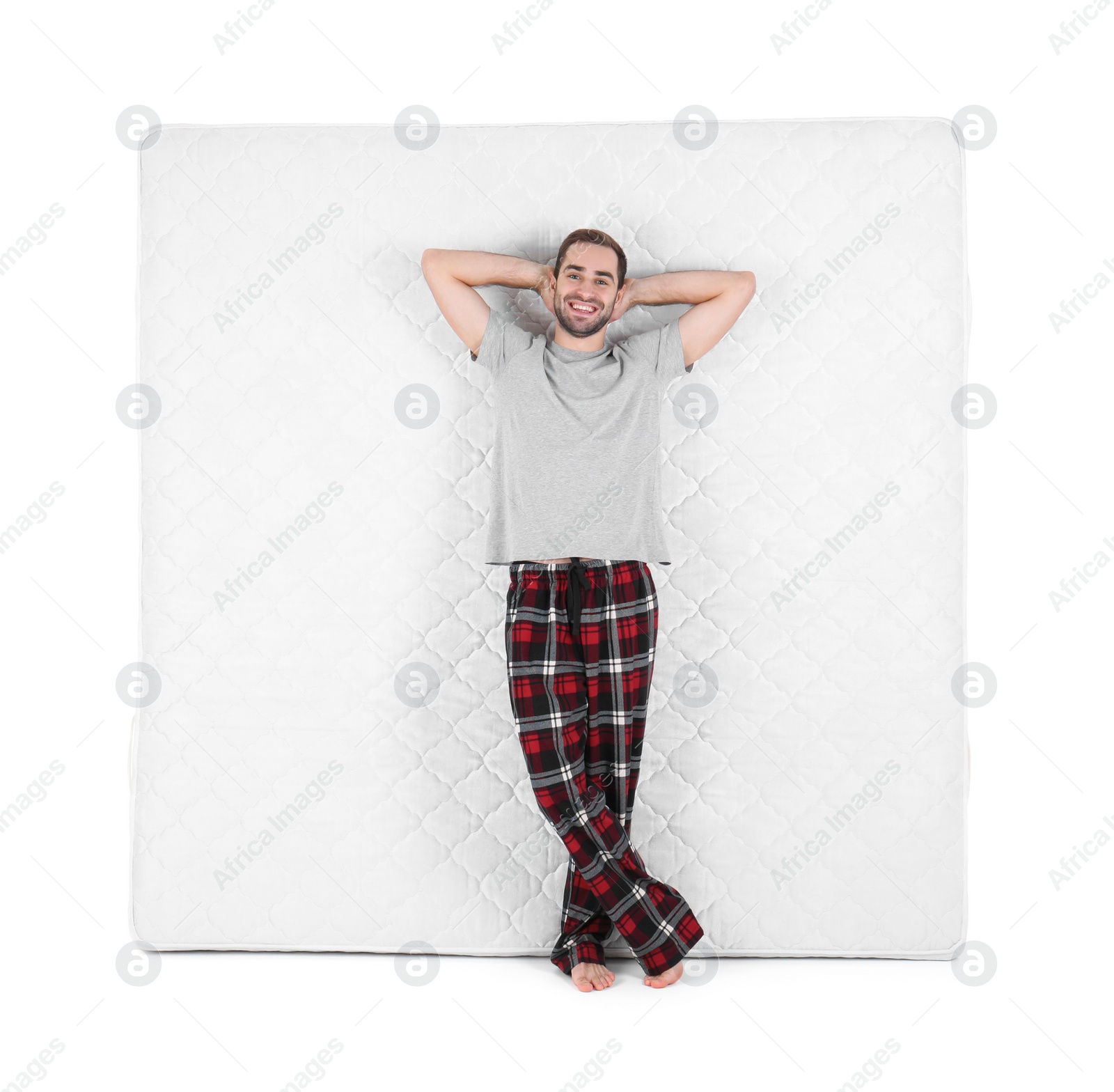 Photo of Young man with comfortable mattress isolated on white