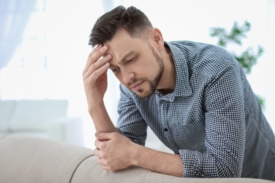 Photo of Man suffering from headache at home