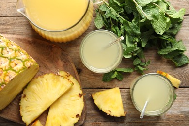 Delicious pineapple juice with fresh fruit and mint on wooden table, flat lay