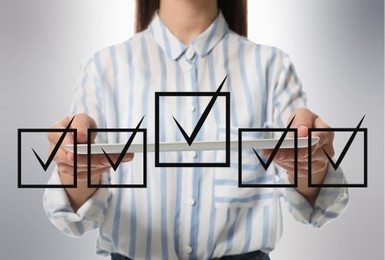 Image of Illustration of check boxes with marks and woman holding tablet on light background, closeup