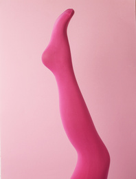 Photo of Leg mannequin in pink tights on color background