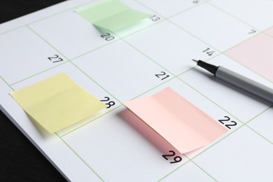 Photo of Timetable. Planner with sticky notes and pen on table, closeup