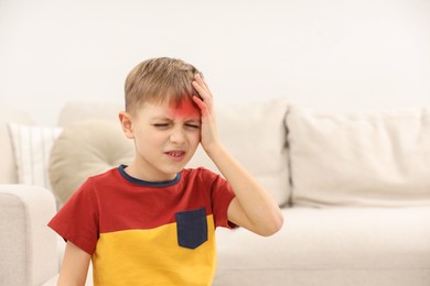Little boy suffering from headache at home