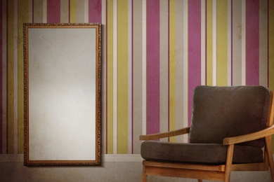 Image of Armchair and mirror near wall with patterned wallpaper. Stylish room interior