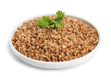 Photo of Plate of buckwheat porridge with parsley isolated on white