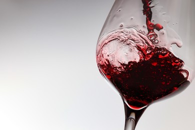 Tasty red wine in glass on white background, closeup. Space for text