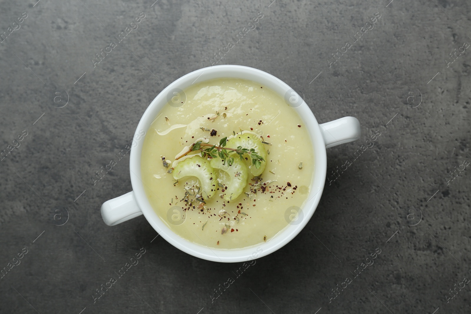 Photo of Bowl of delicious celery soup on gray table, top view