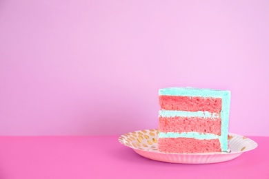 Slice of fresh delicious birthday cake on table against color background. Space for text