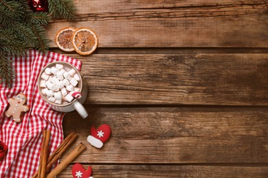 Photo of Flat lay composition of delicious hot chocolate with marshmallows and Christmas decor on wooden table, space for text