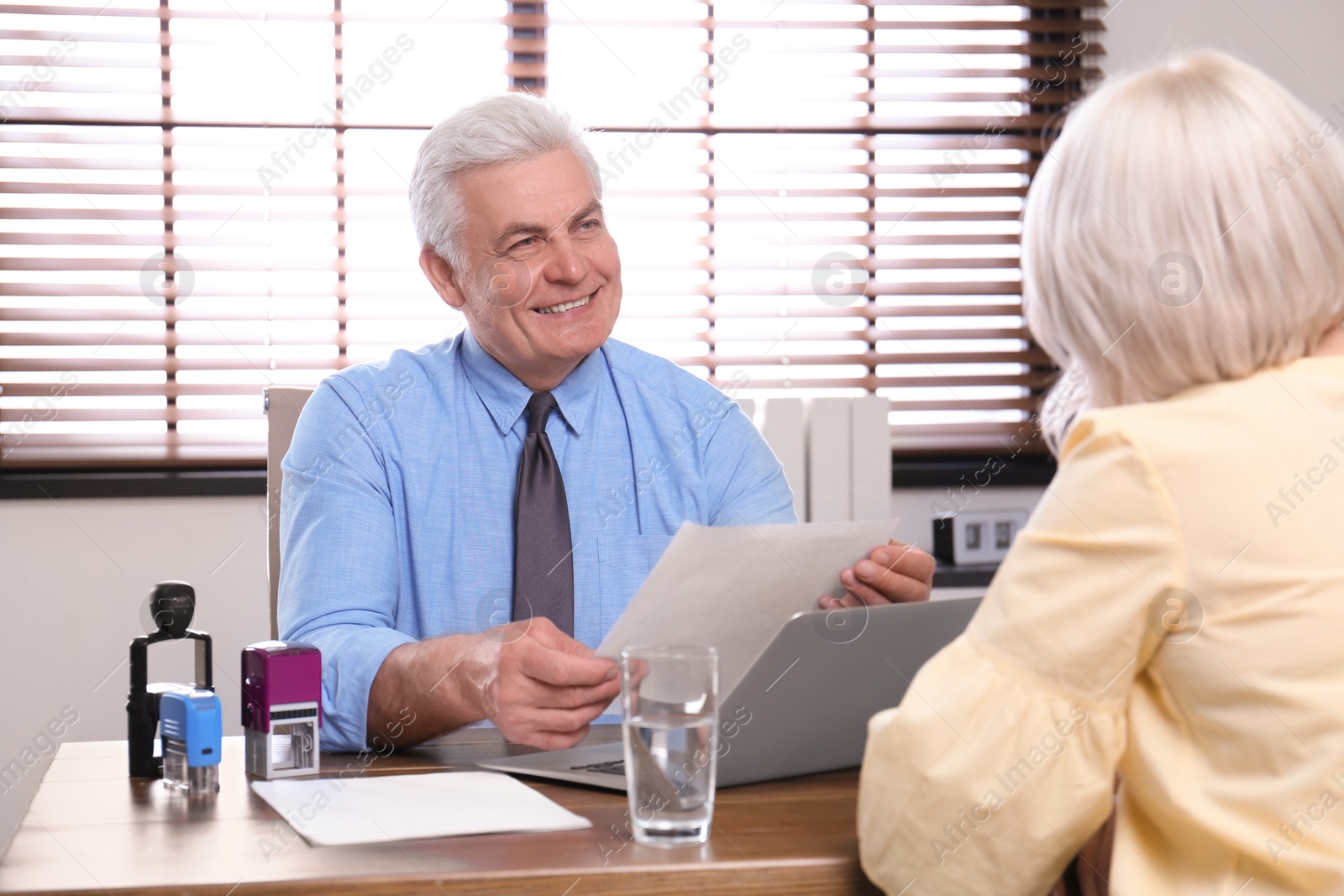 Photo of Senior notary working with client in office
