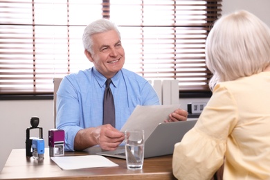 Senior notary working with client in office