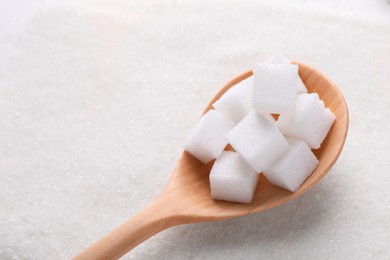 Photo of Different types of white sugar and spoon as background, above view. Space for text