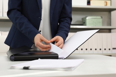 Woman working with documents at table in office, closeup