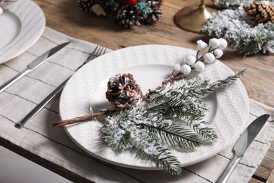 Photo of Plate with cutlery and festive decor on wooden table