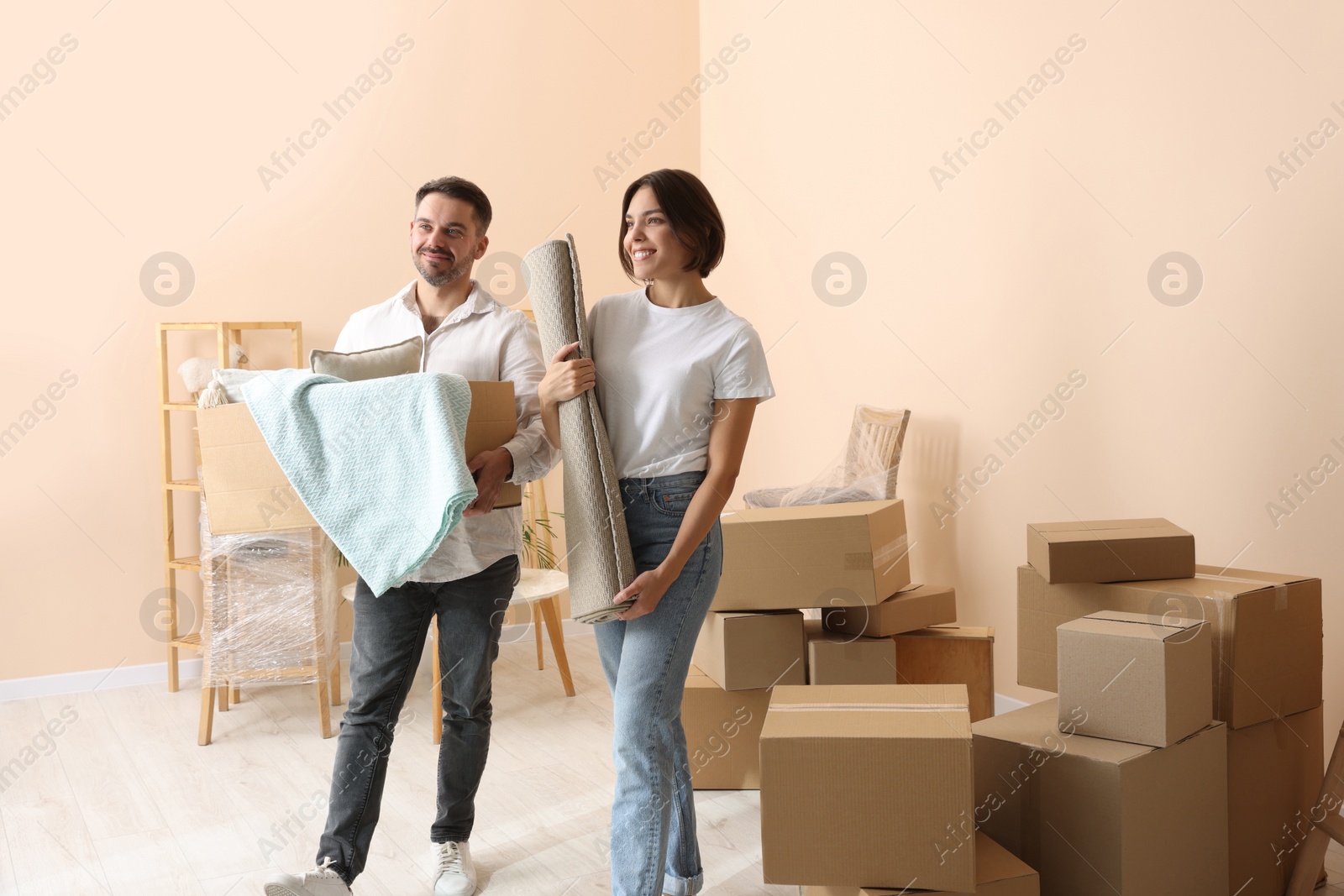 Photo of Happy couple with stuff in new apartment. Moving day