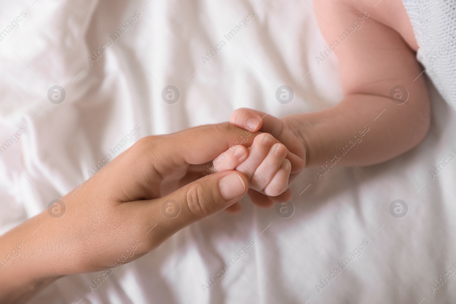 Photo of Mother and her newborn baby on bed, top view