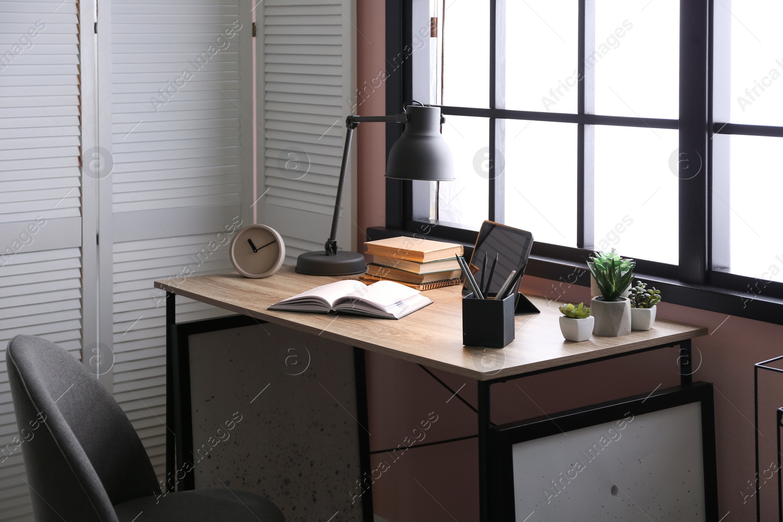 Photo of Stylish room interior with comfortable workplace near window