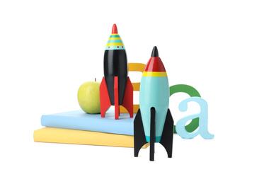 Bright toy rockets and school supplies on white background