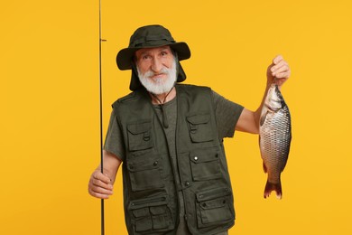 Photo of Fisherman with rod and catch on yellow background