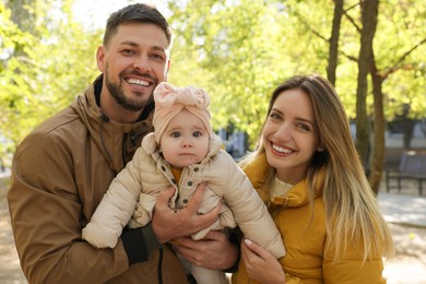 Photo of Happy parents with their baby in park on sunny day