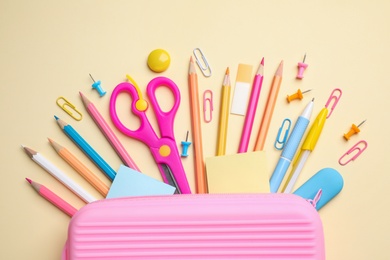 Photo of Case with different stationery on yellow background, flat lay