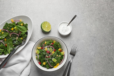 Photo of Tasty fresh kale salad on light grey table, flat lay