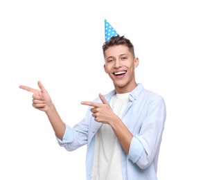 Photo of Happy young man in party hat pointing at something on white background