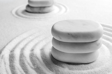 Photo of Stack of white stones on sand with pattern, space for text. Zen, meditation, harmony