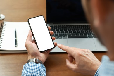 Photo of Man using smartphone at table, closeup view