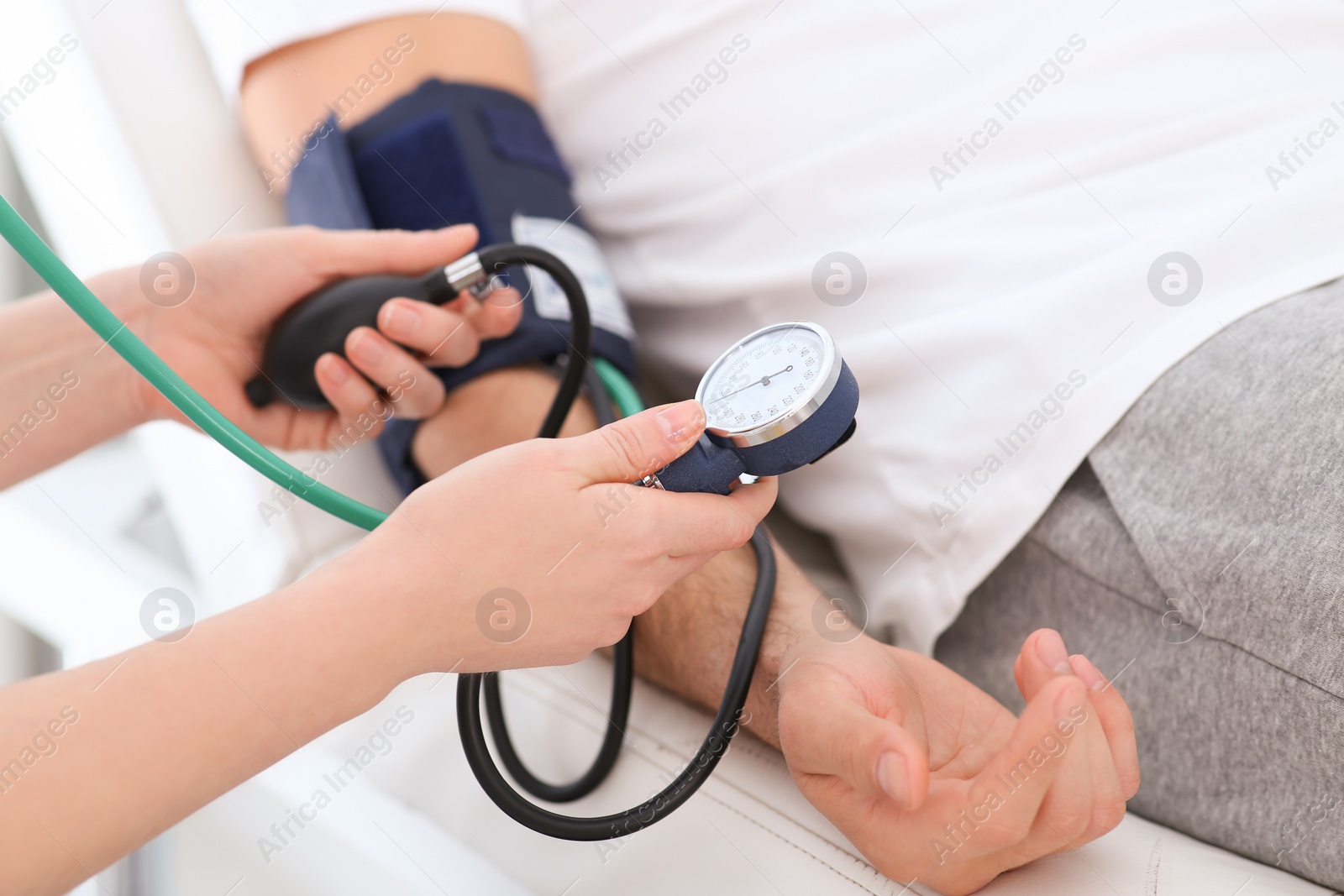 Photo of Doctor checking blood pressure of man in clinic, closeup