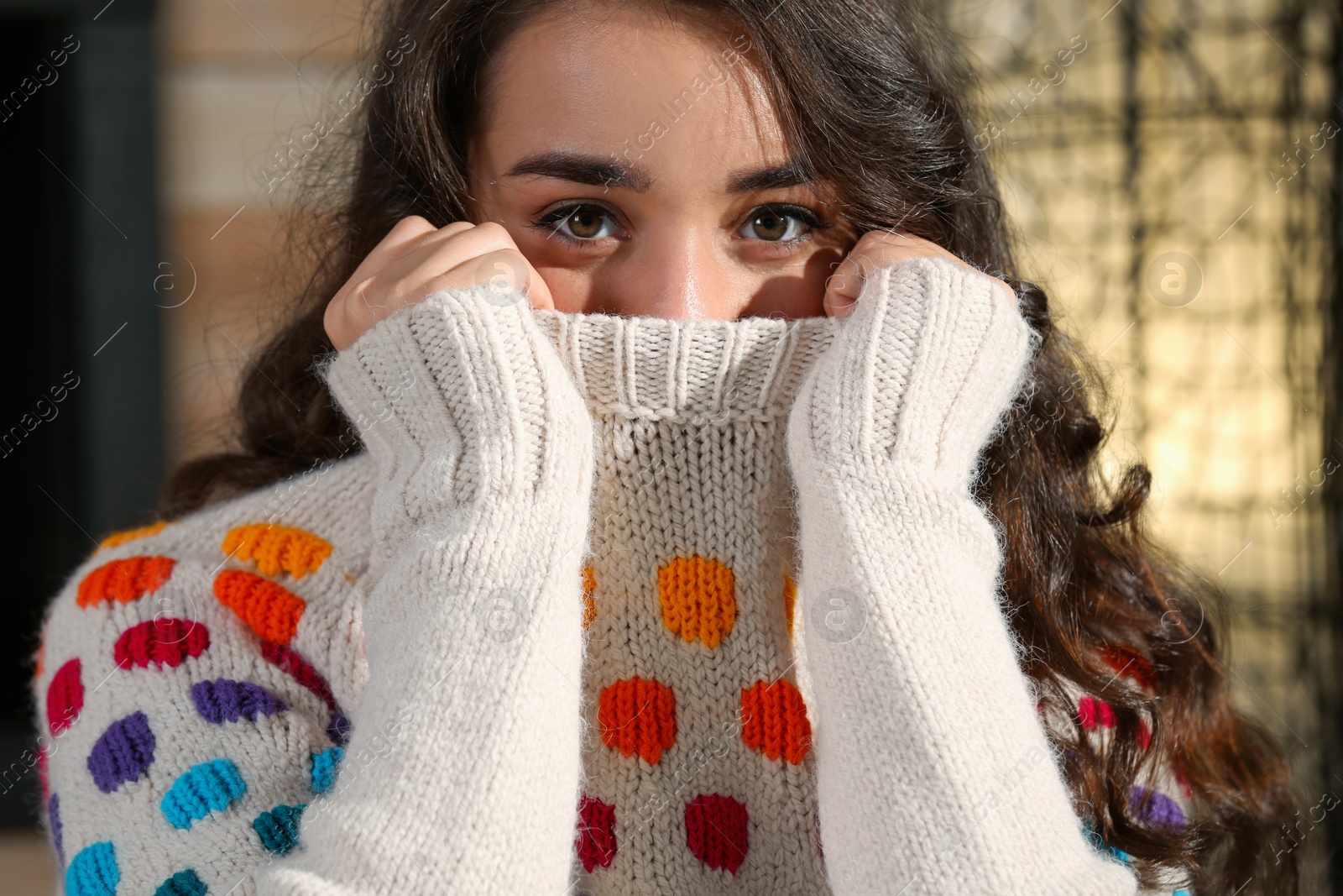 Photo of Portrait of young beautiful woman in warm sweater at home